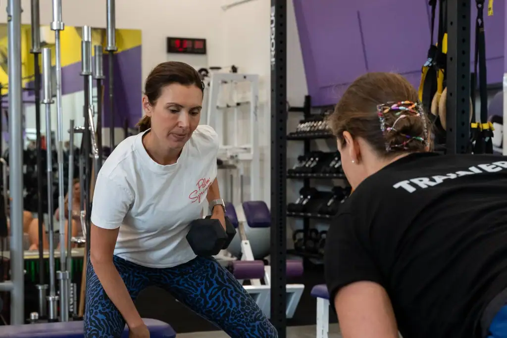 A trainer correcting a member’s form during a one-to-one session